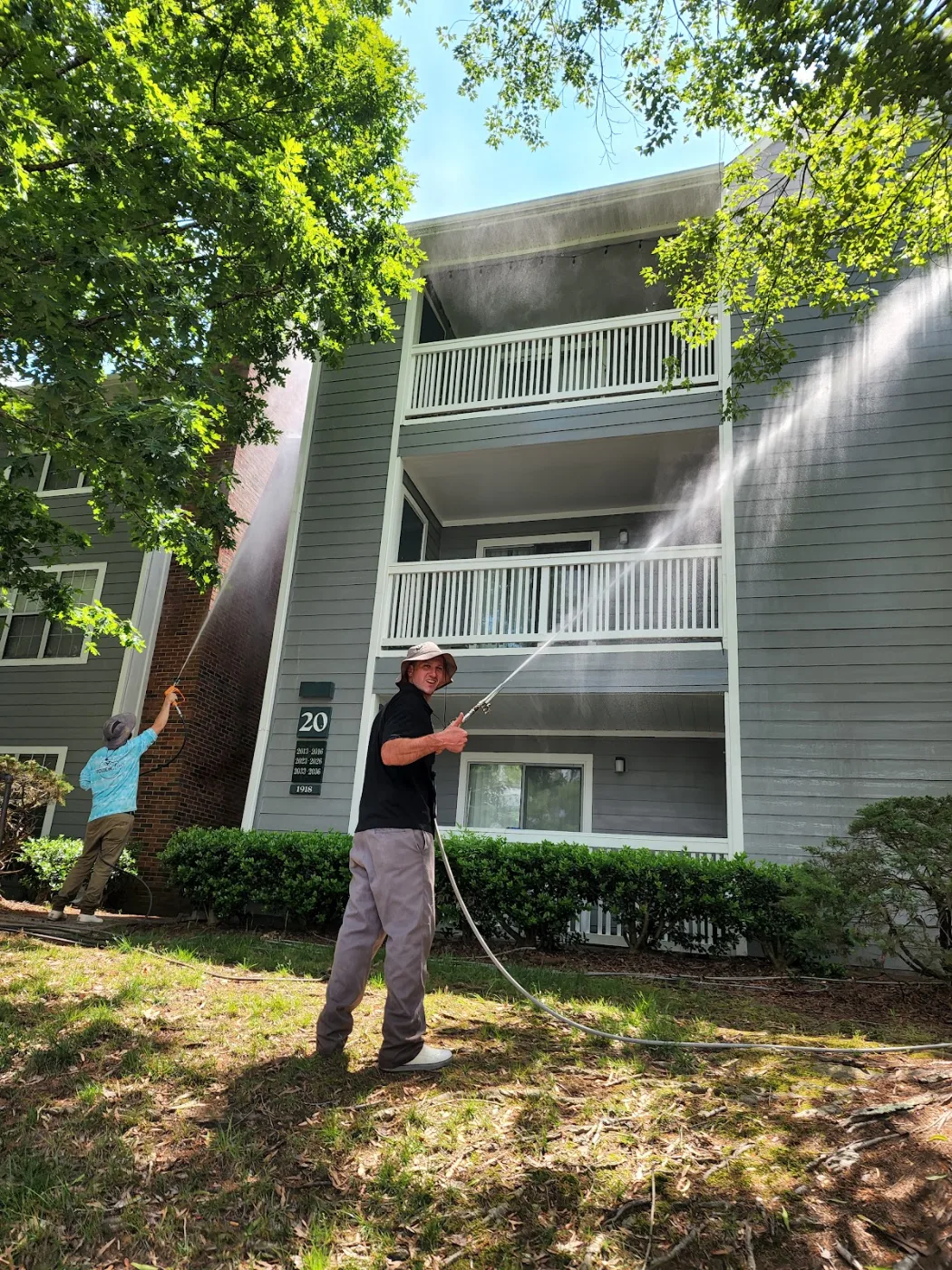 Soft washing the siding and balconies of an apartment building