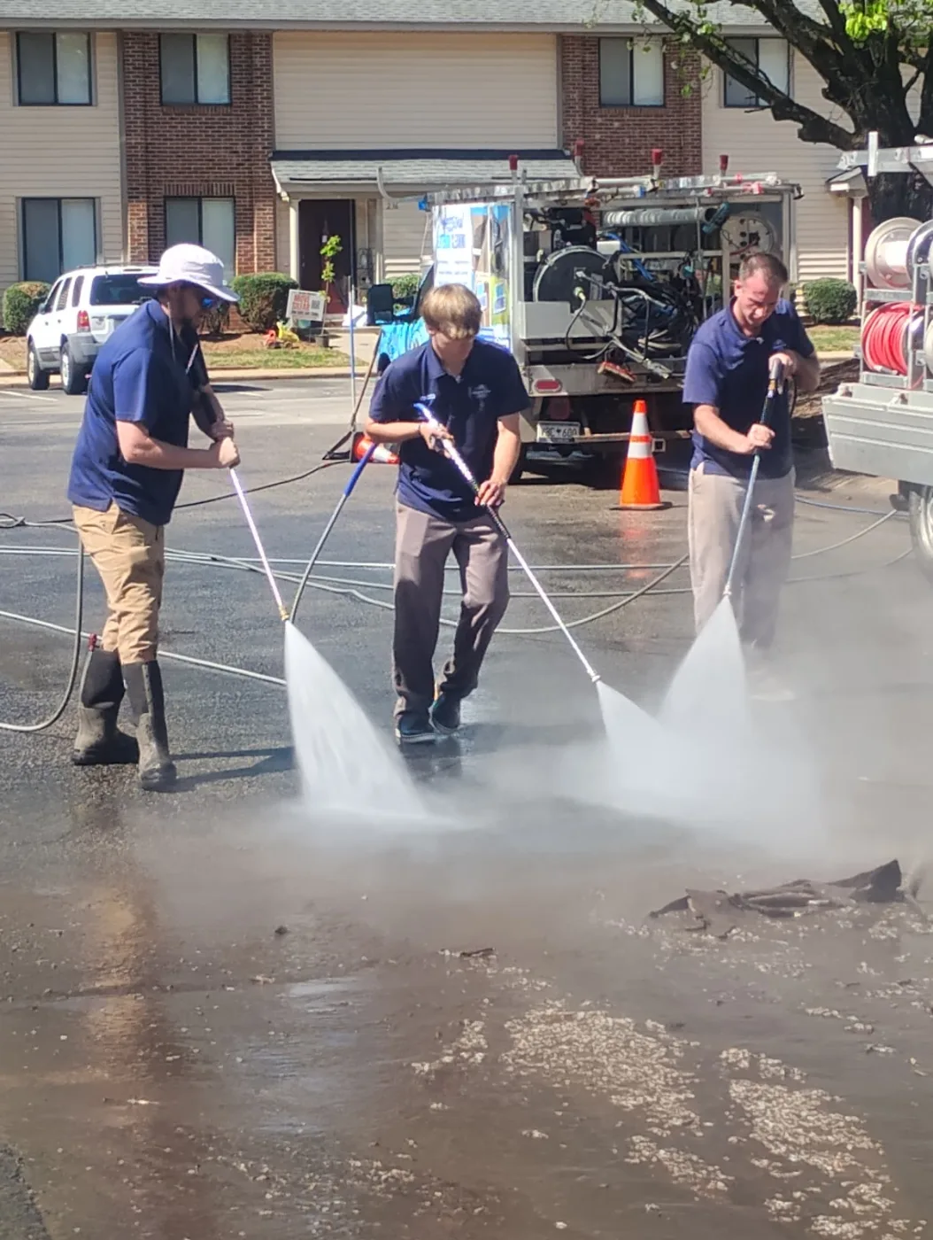 Power Clean crew pressure washing a commercial parking area